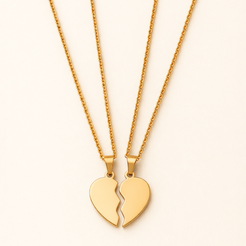 Pair of 18k gold plated heart necklace halves hanging on delicate gold chains against a neutral background.
