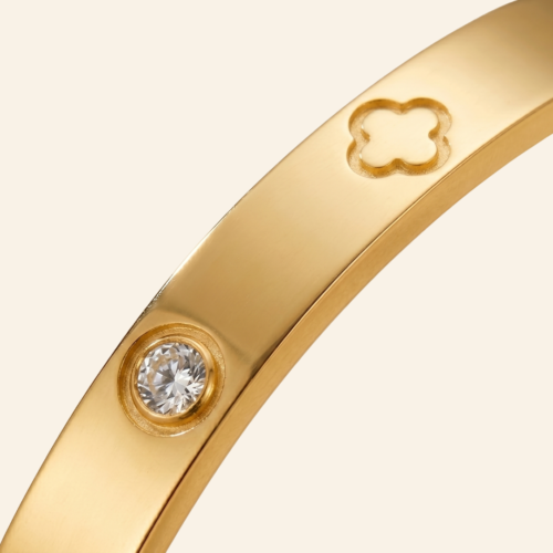 The Gift Maison luxury gold clover bangle with cubic zirconia crystals shown on a plain studio background