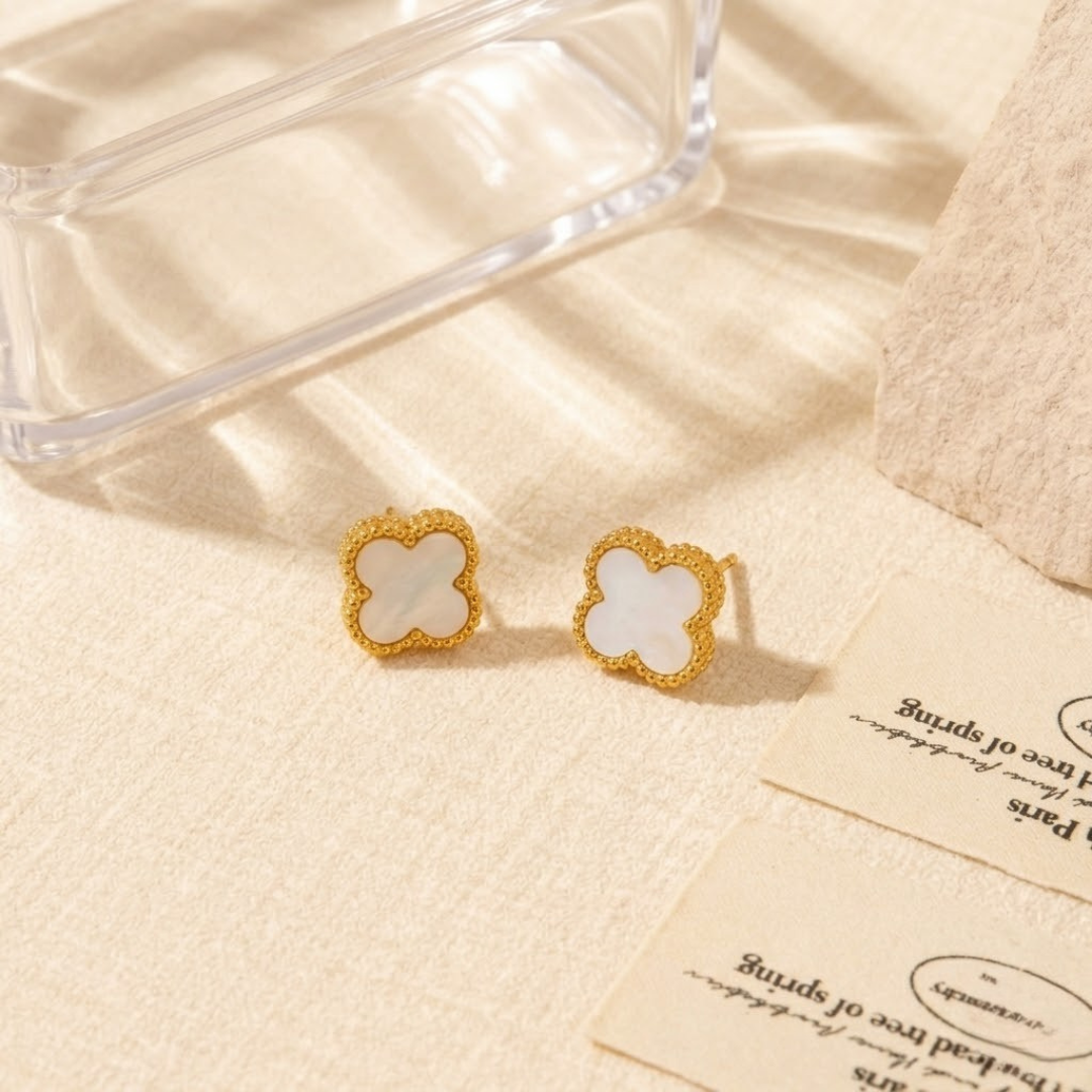 Luxury white clover stud earrings with beaded gold borders next to French typography cards