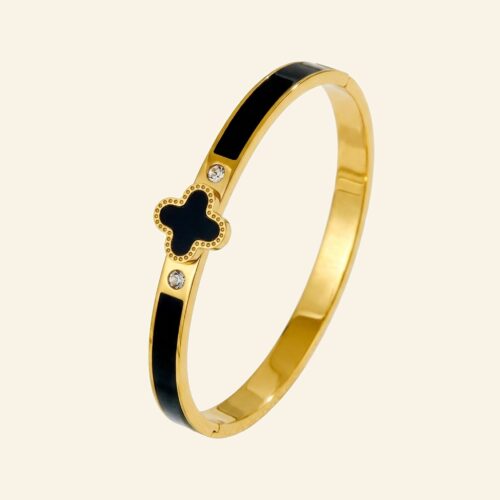Gold bangle with a black enamel four-leaf clover and a single crystal