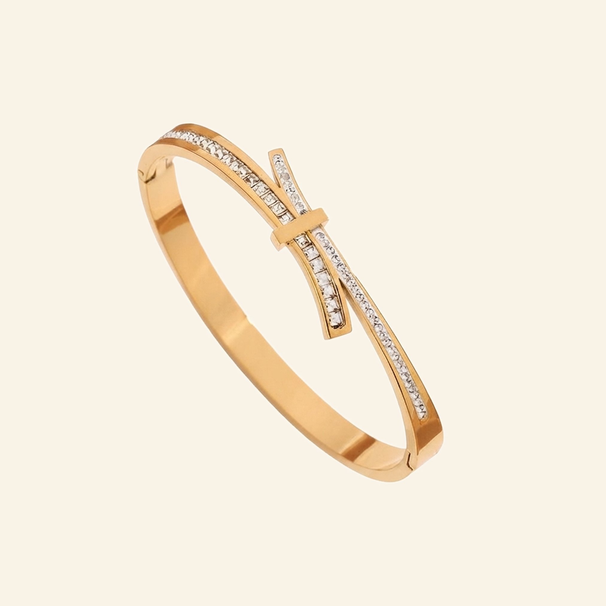 Gold bow bangle with crossover bands, one side set with pavé crystals