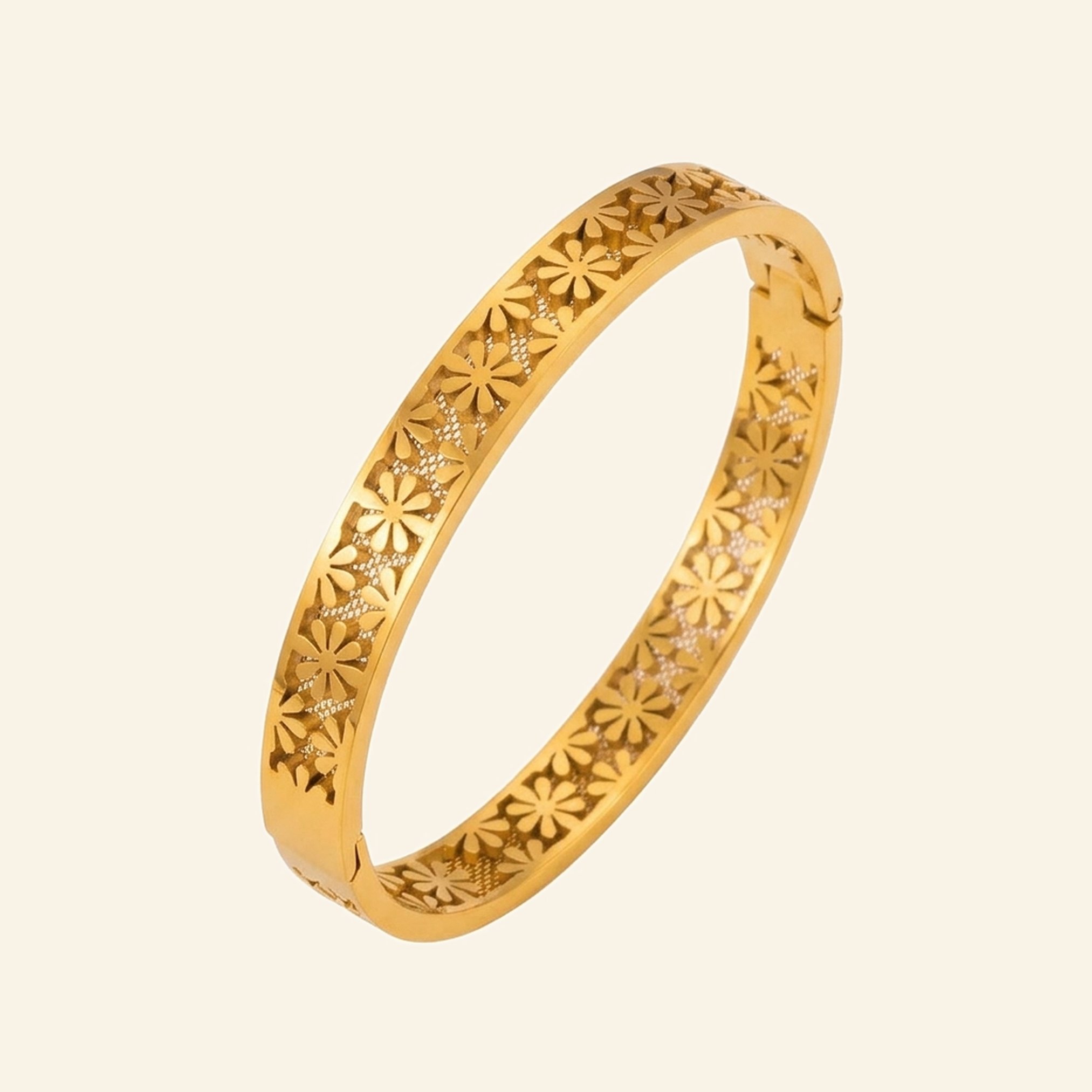 Wide gold bangle with a pierced daisy flower pattern around the band