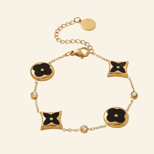 Gold flower charm bracelet with black floral charms, stars and crystals