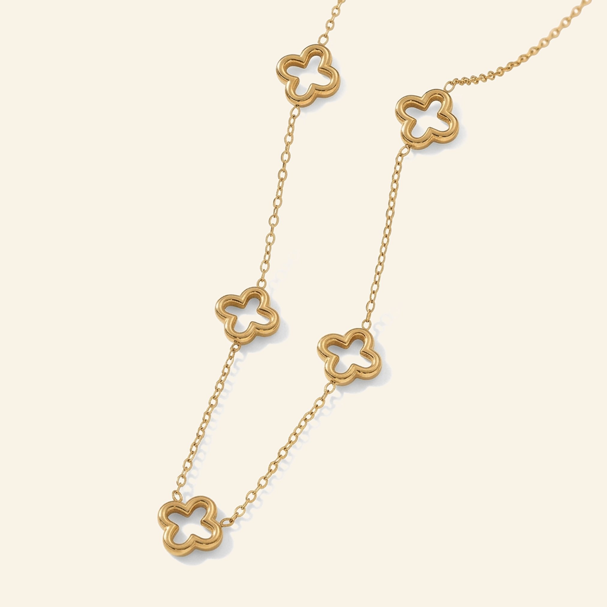 Gold necklace with open hollow four-leaf clover stations