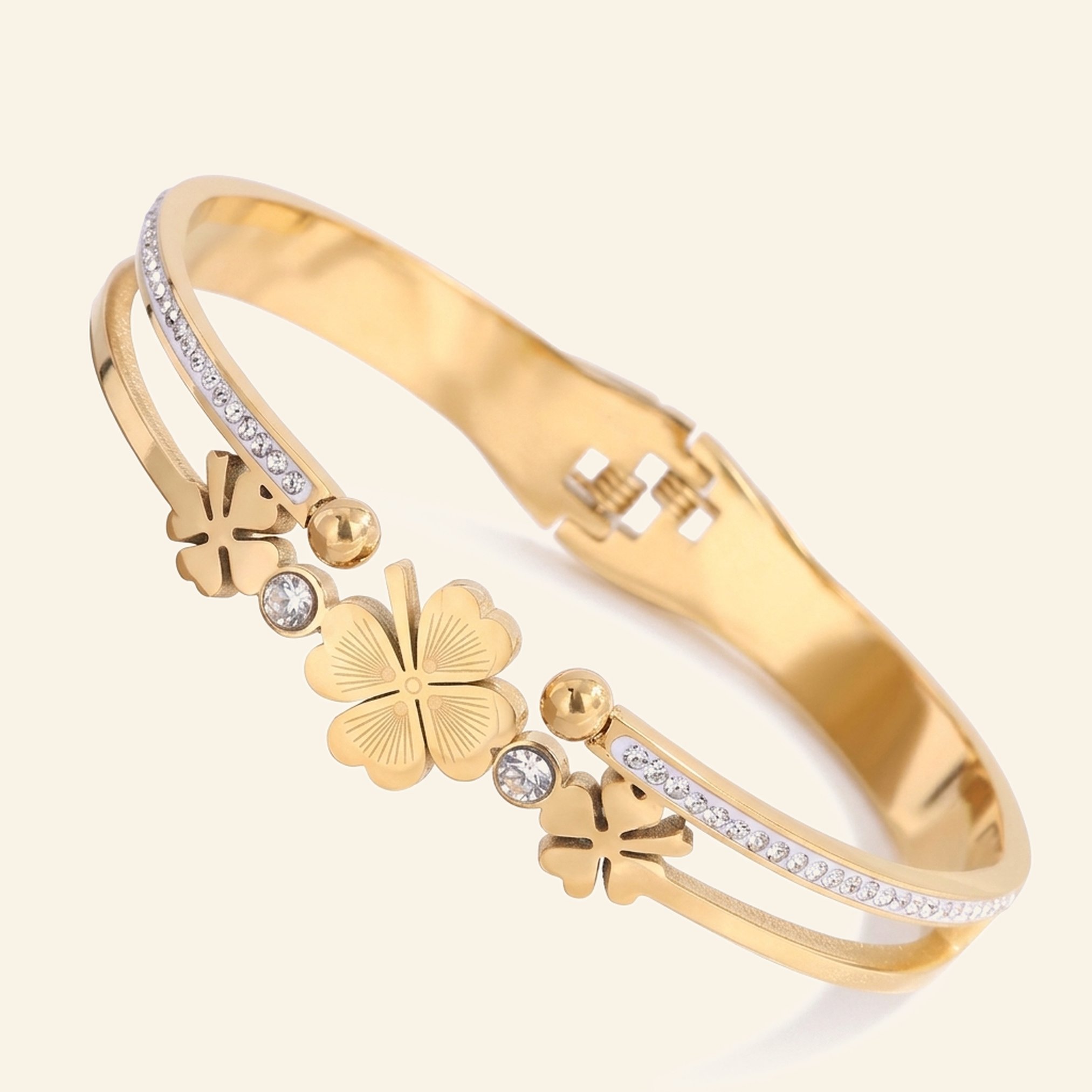 Gold clover cuff bangle with three four-leaf clovers and a crystal band