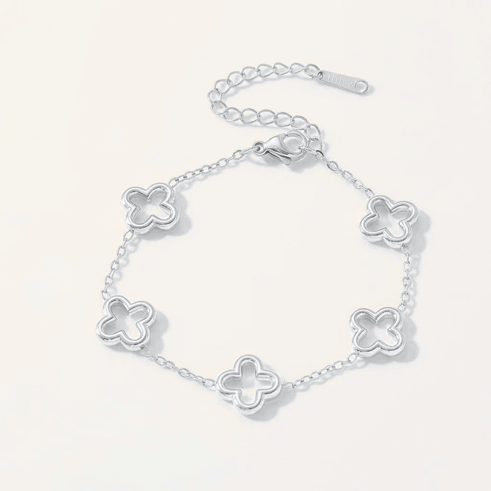 Silver bracelet with open hollow four-leaf clover stations